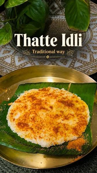 Traditional thatte idli served on a banana leaf